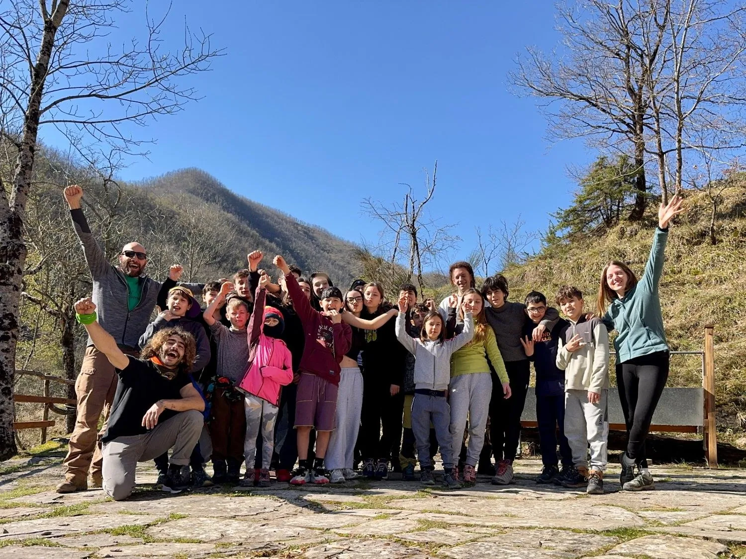 Il gruppo del settore giovanile con gli istruttori, braccia alzate durante un campo in montagna